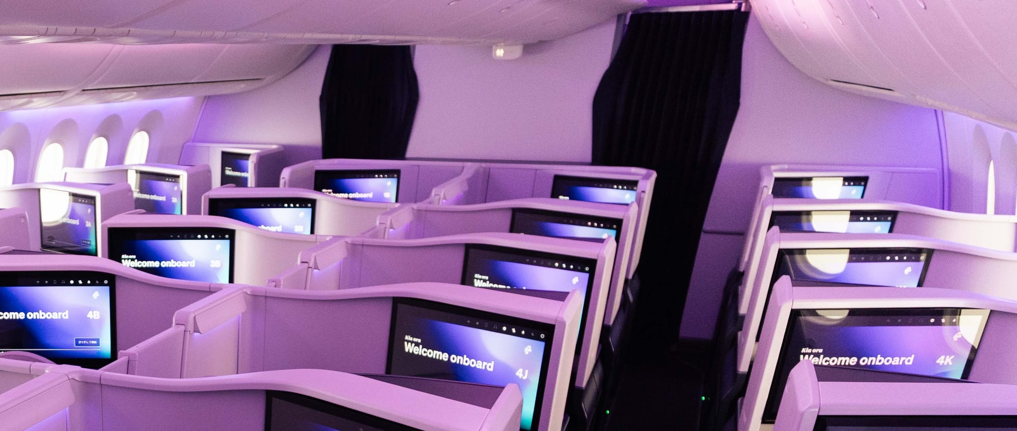 Interior, airline cabin, business class, zoomed in at the front row. The expanded monuments for the front row suites are entirely separate to the bulkhead walls in front of them.