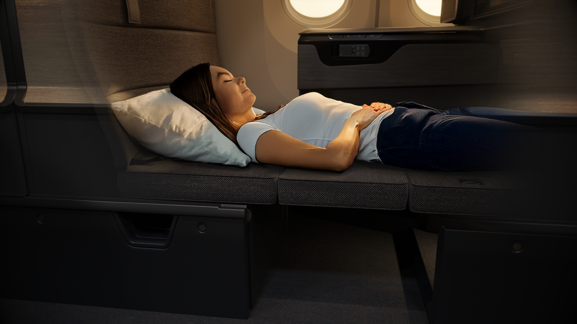 Interior, business class cabin, seat cutaway rendering. The passenger is shown sleeping on the flat surface where the footrest has met the ottoman and seat surface.