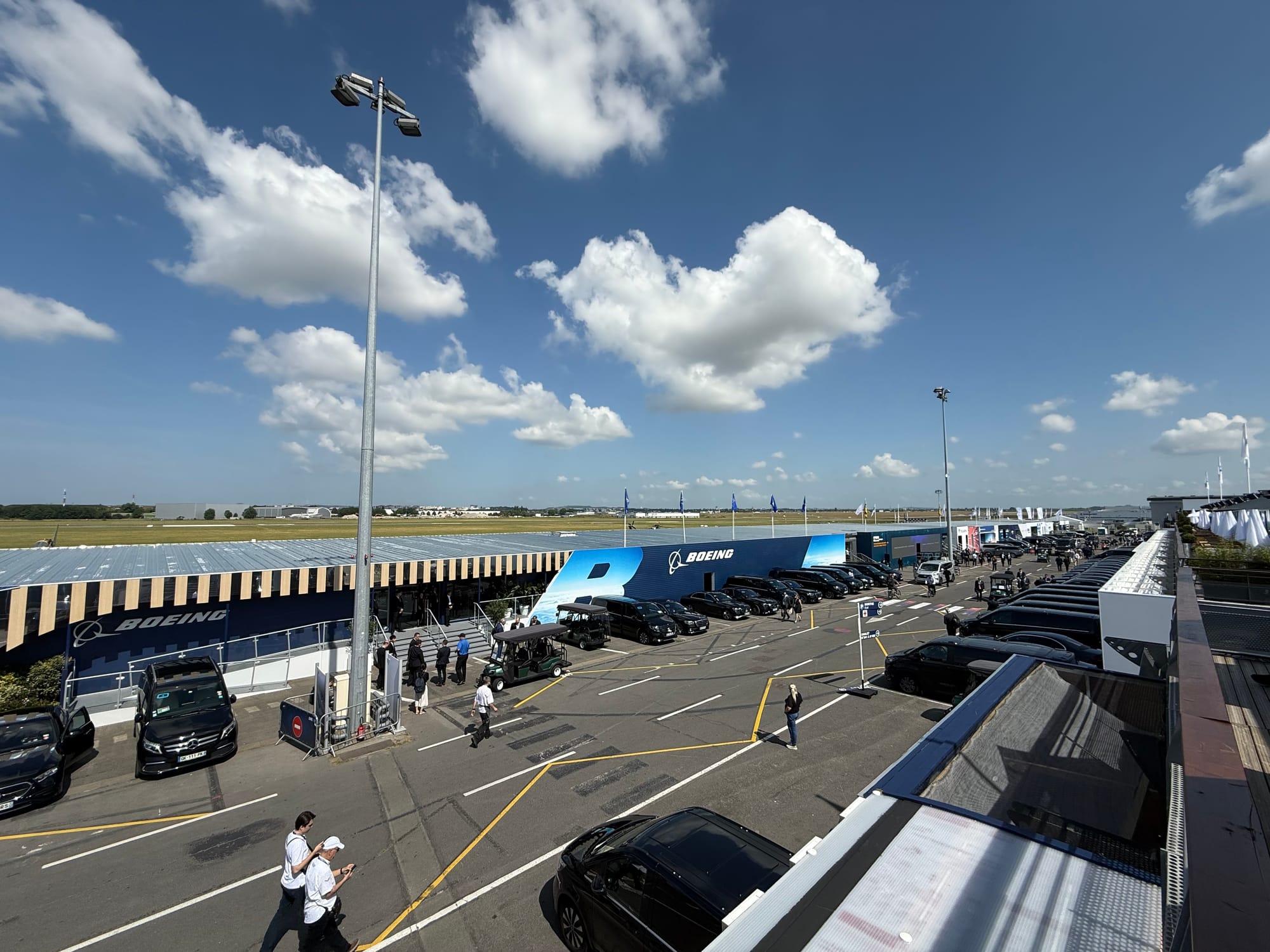 Chalet Row: a 2-lane sort of road between 1-2 storey buildings, with aerospace company logos, branding and flags. There's not a lot of traffic.