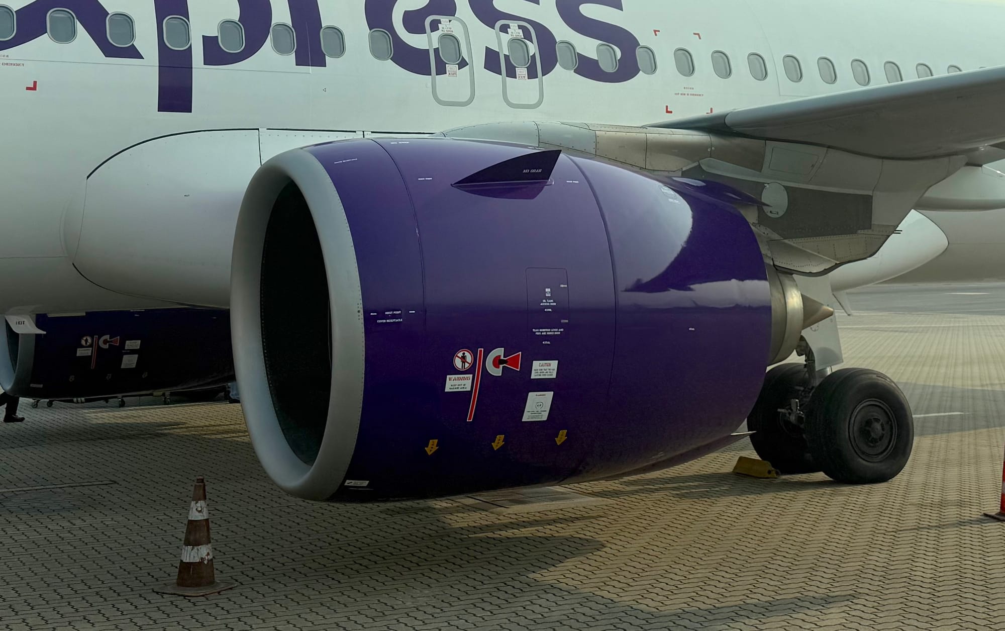 A closeup of a purple P&W PW1100G engine at a parking stand.