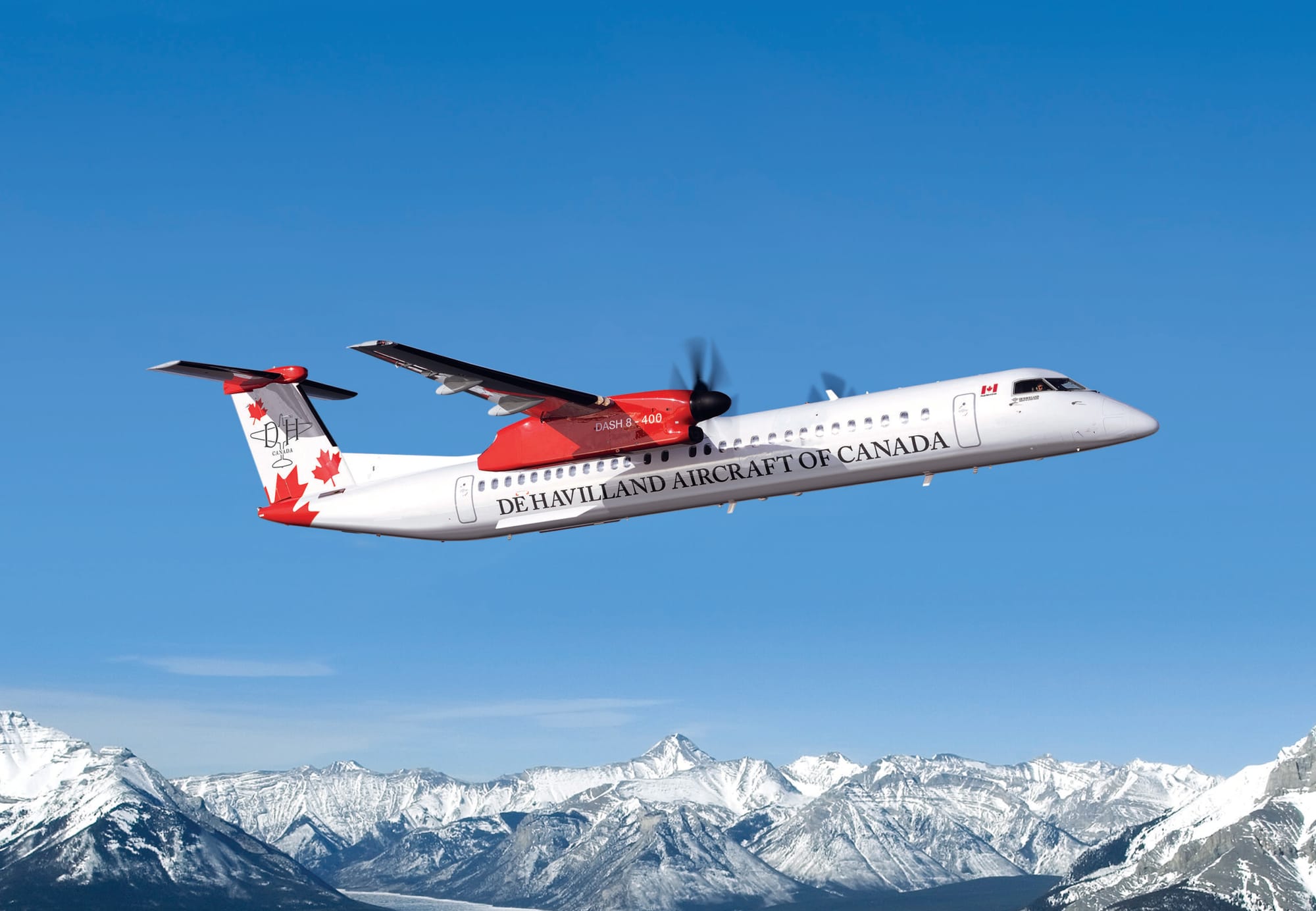 A DHC liveried white and red Q400 over mountains