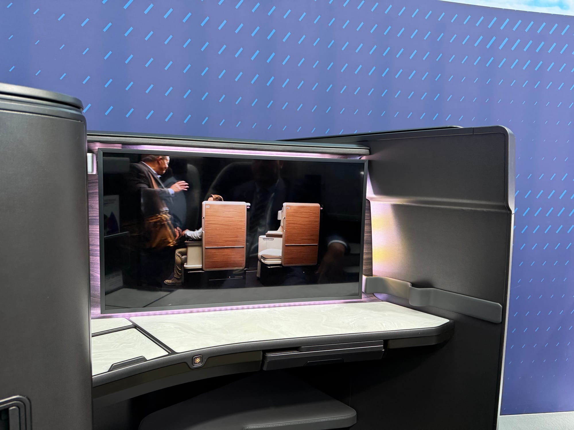 Mockup, business suite. A large (30 inches or so?) flatpanel monitor at the front of a studio class suite.