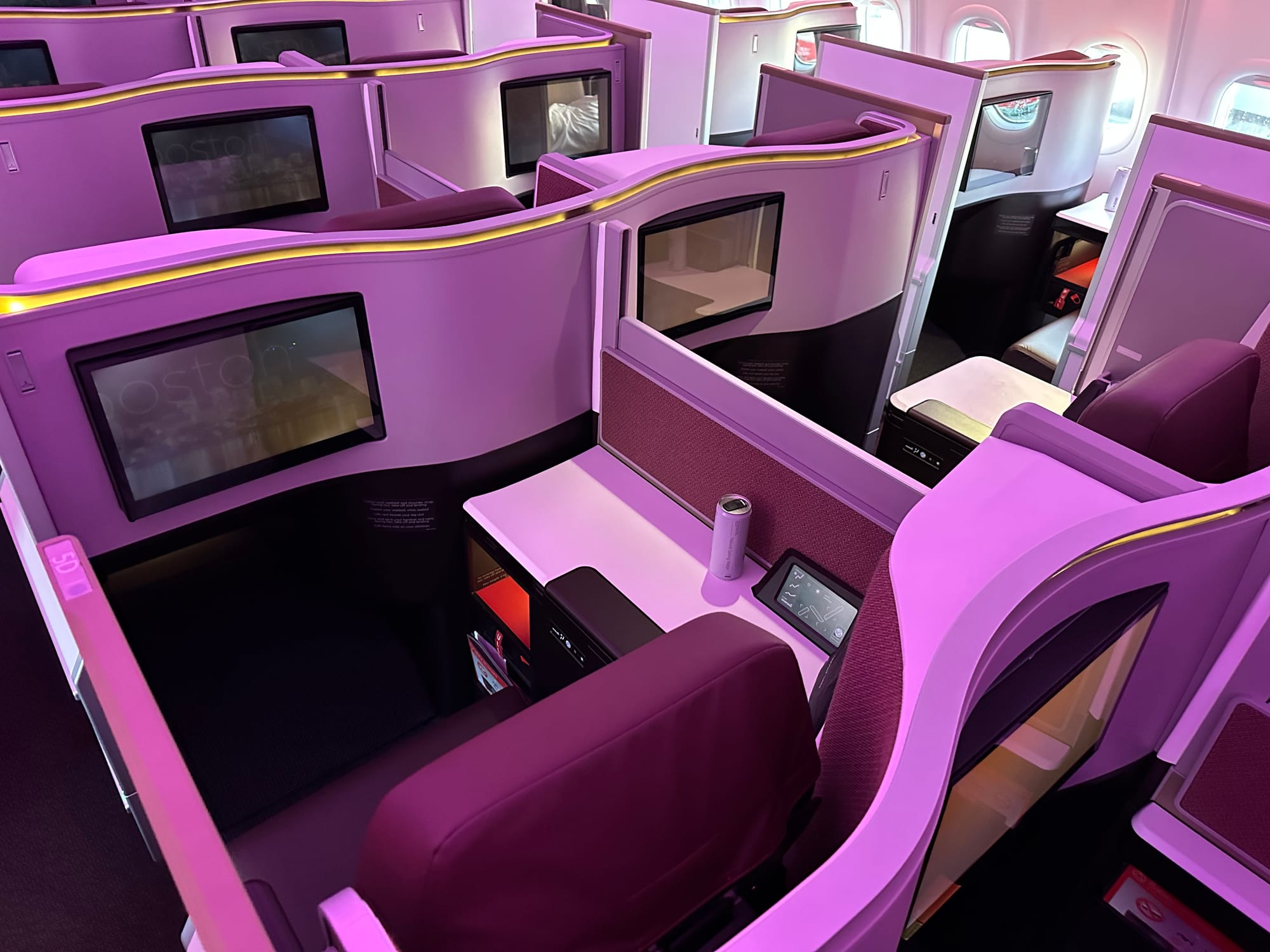 Interior, Virgin Atlantic A330neo, Upper Class. Centre section of Thompson Vantage XL doored suites in pink-purple washed LED lighting with red accents.