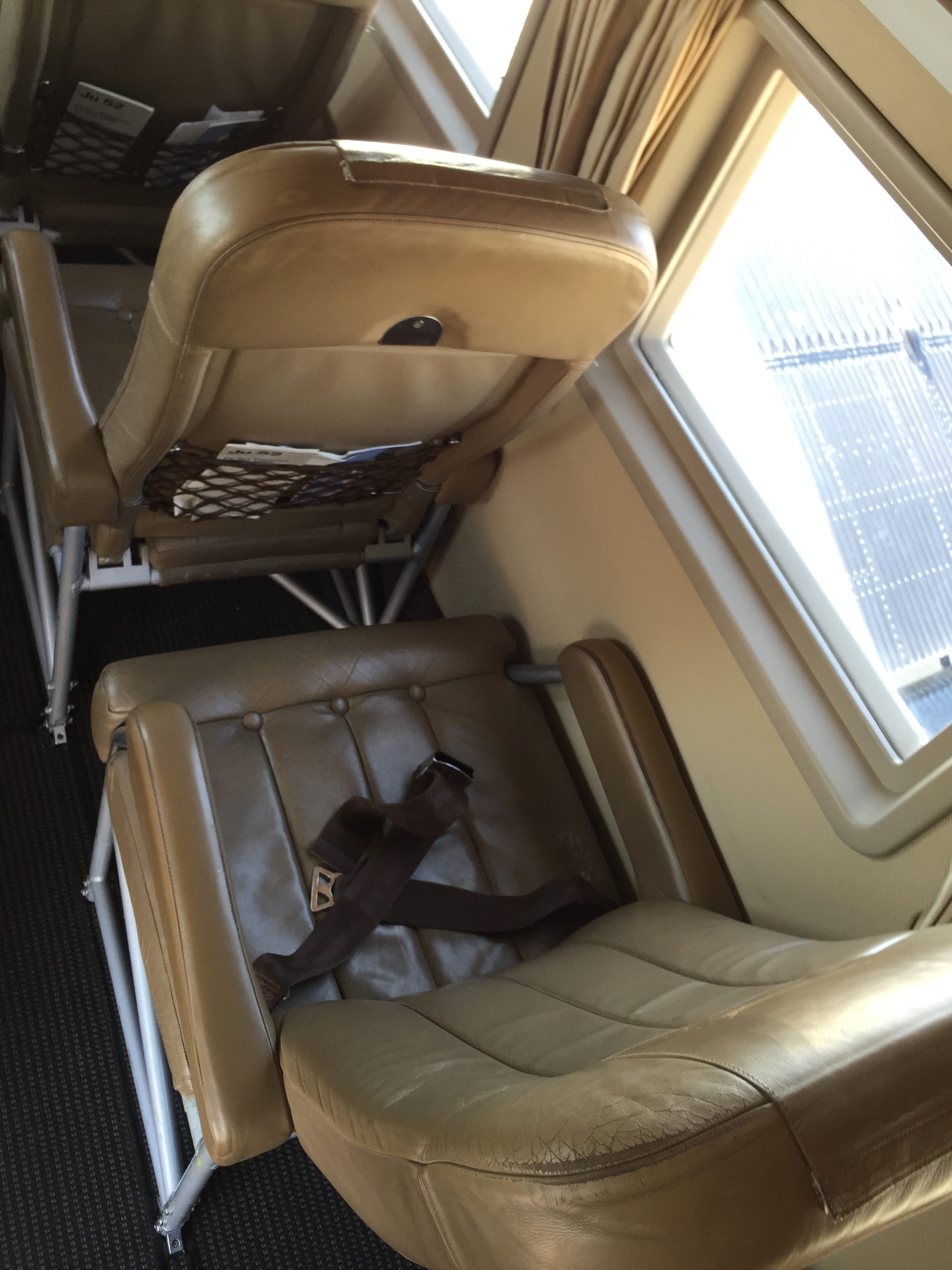 Looking down on the seats, which are beige leather and relatively deep, but with perhaps 15cm of legroom ahead of the front edge of the deep seat pan.
