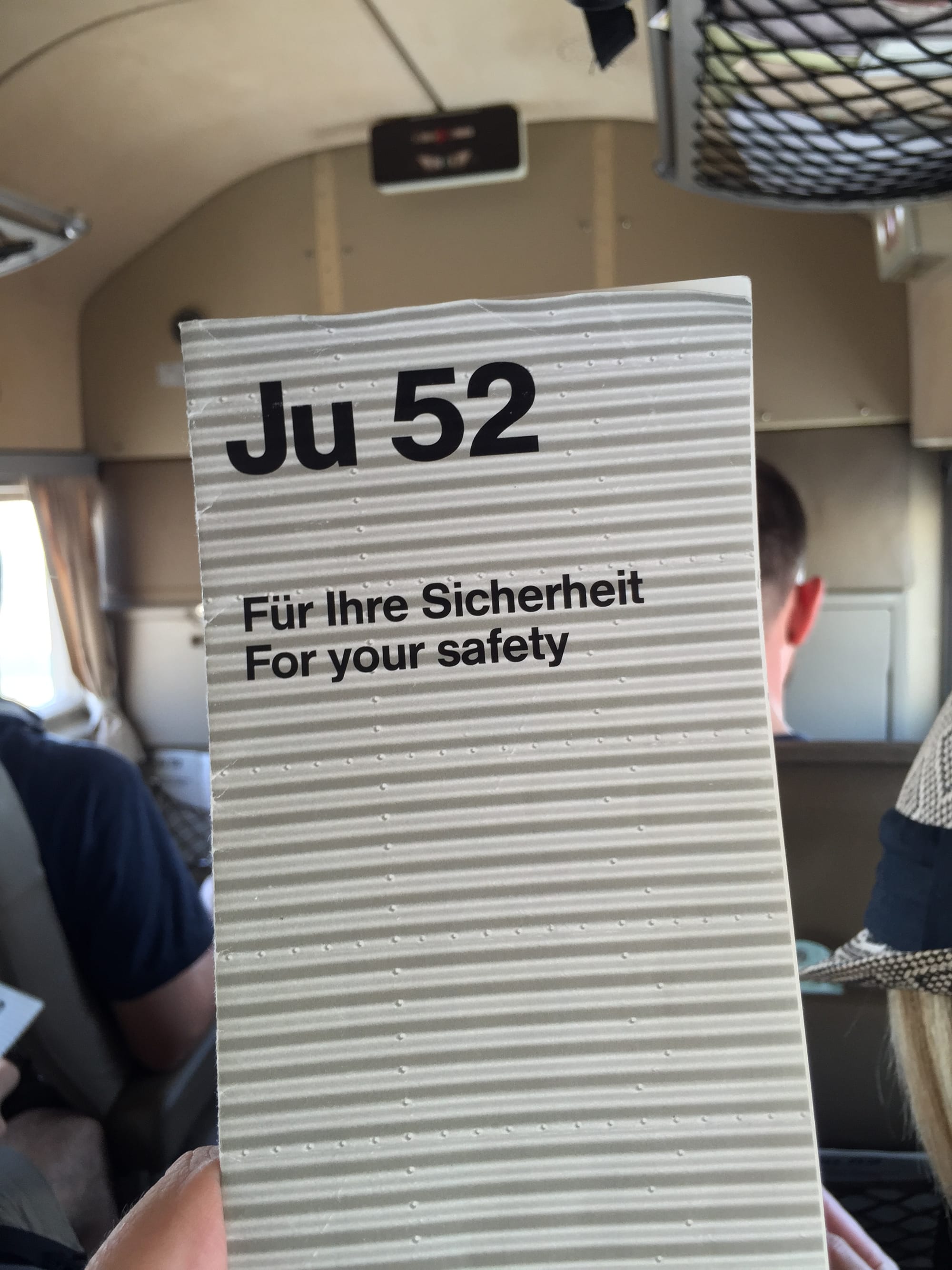 A safety card for the flight, whose front page background is the corrugated aluminium skin of the Ju 52