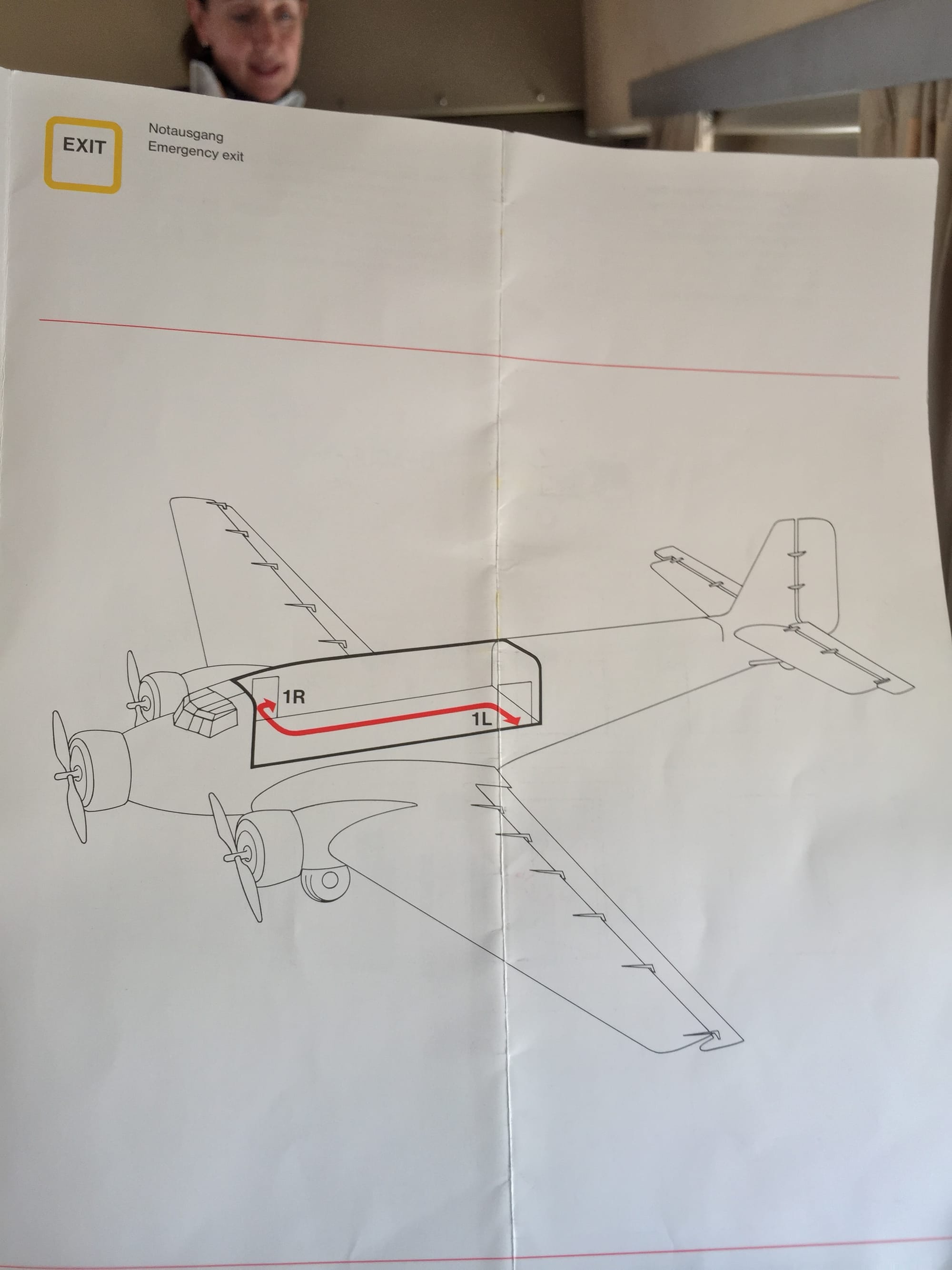 The other side of the unfolded safety card, showing the two exits to 1R at the front right of the cabin and 1L at the rear left.