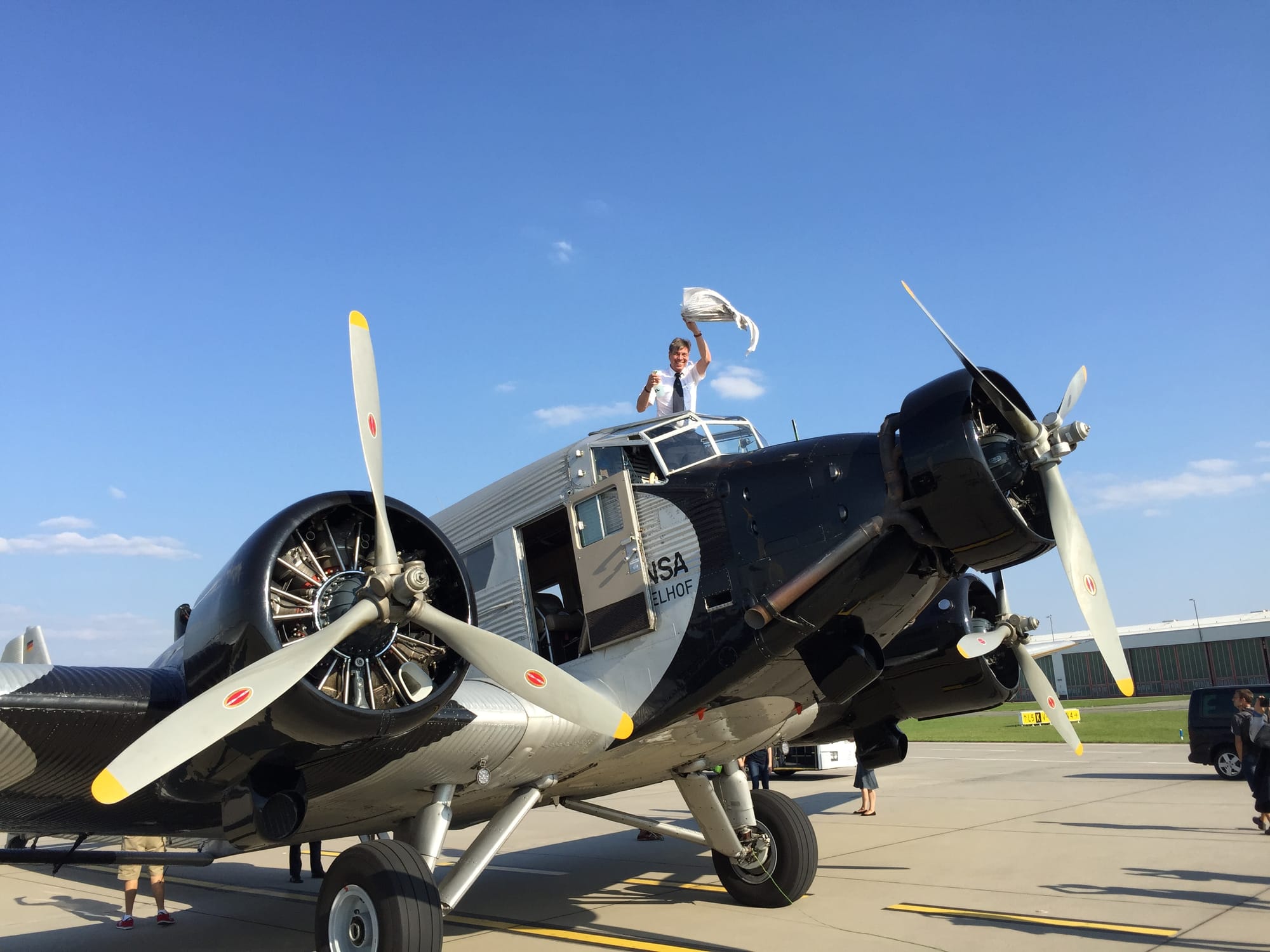 One of the pilots standing up out of the top of the flight deck and waving a cleaning rag
