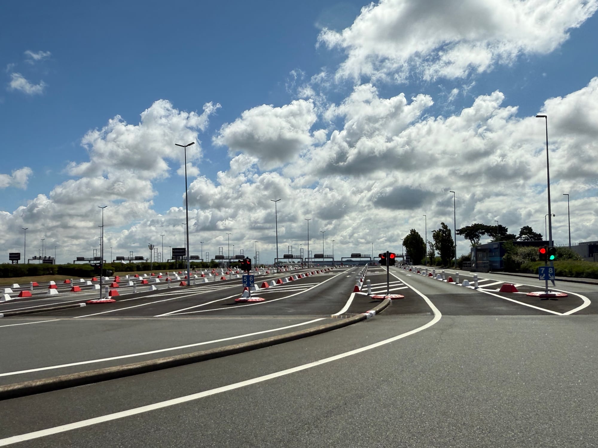 A similar traffic queueing area to the previous one, with a half-dozen or so lanes.