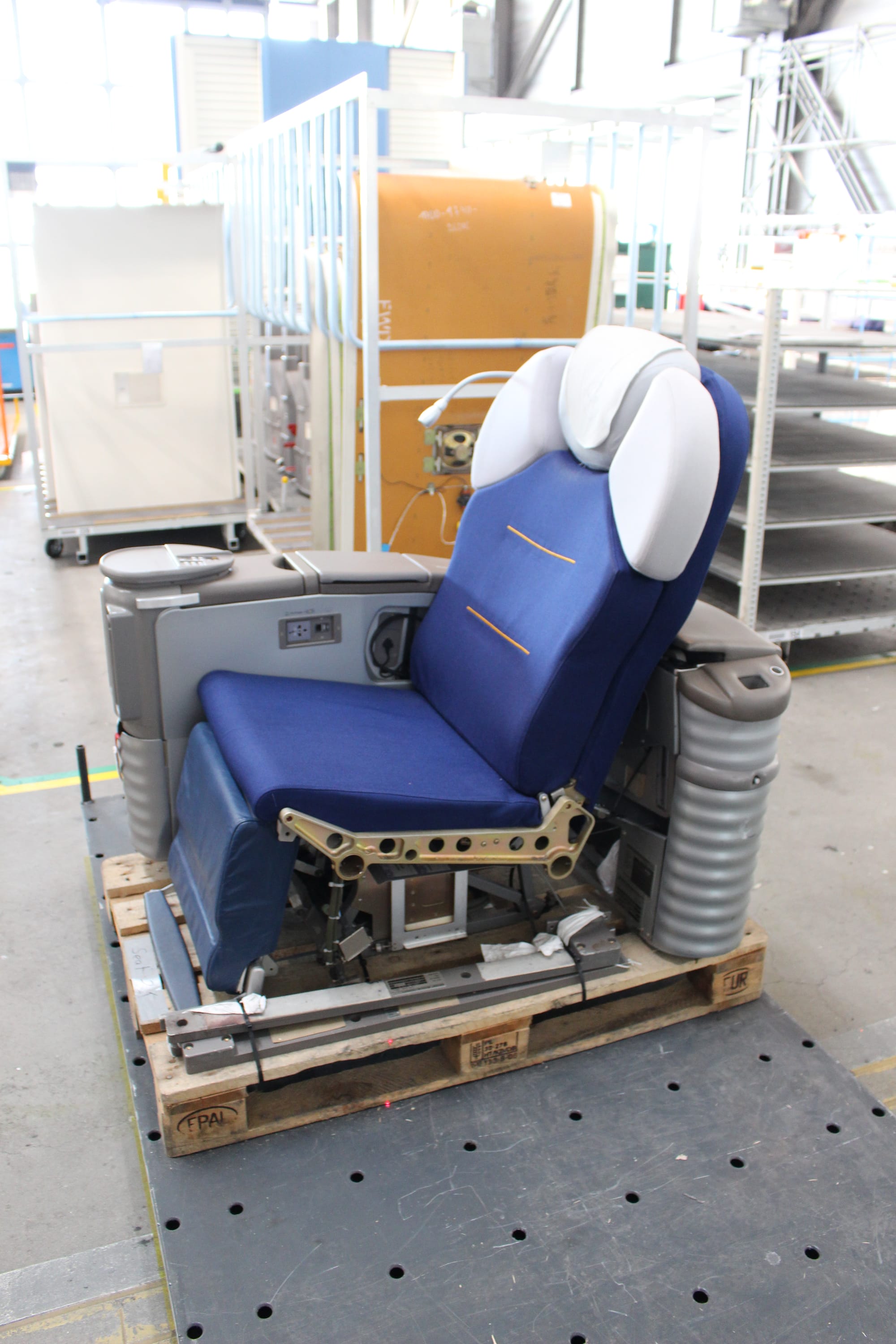 Closeup of a partially disassembled Lufthansa first class seat of two generations ago, showing the corrugated plastic clearly.