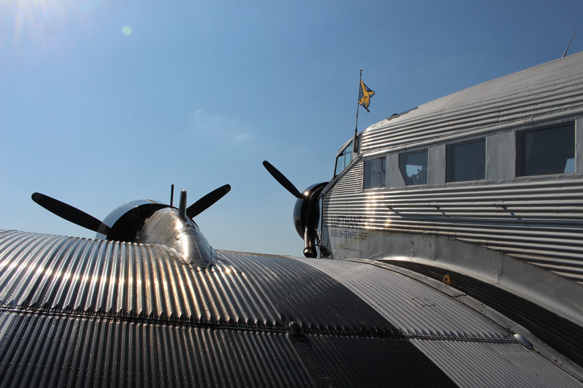 Closeup of the left wing from behind, with the corrugated aluminium ribs caught in the light.