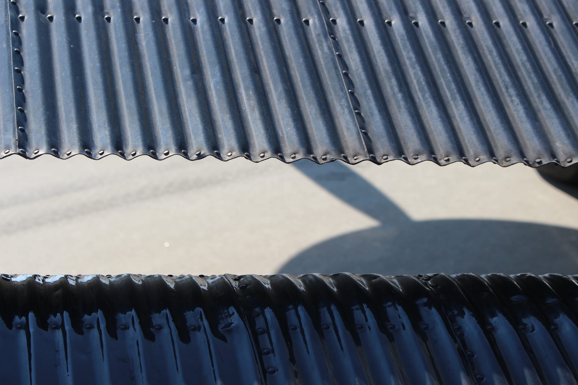Super-close-up on the rear edge of the wings and the front end of the trailing edge control surfaces, showing the corrugation and rivets.