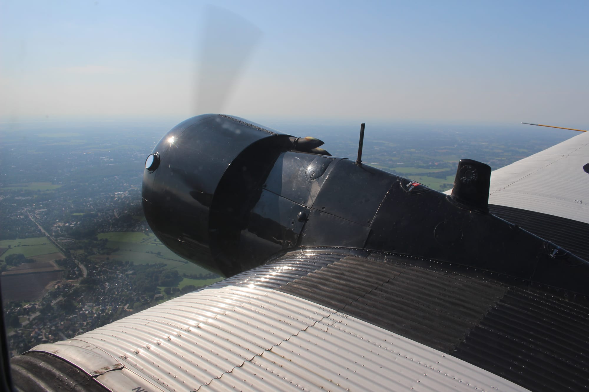 In-air shot of the spinning right engine, with suburban Hamburg and fields below
