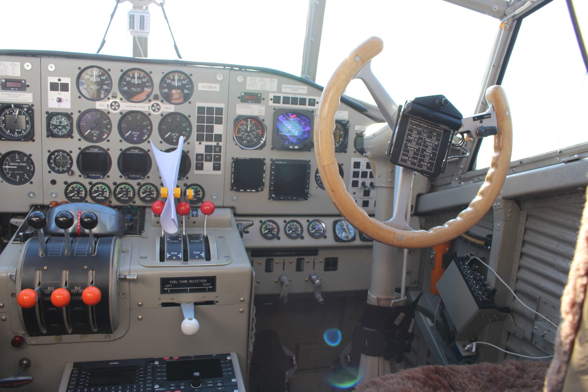 Closeup on the right side of the flight deck, with many gauges and the flight yoke, as well as various newer elements installed like radios and screen-based attitude indicator
