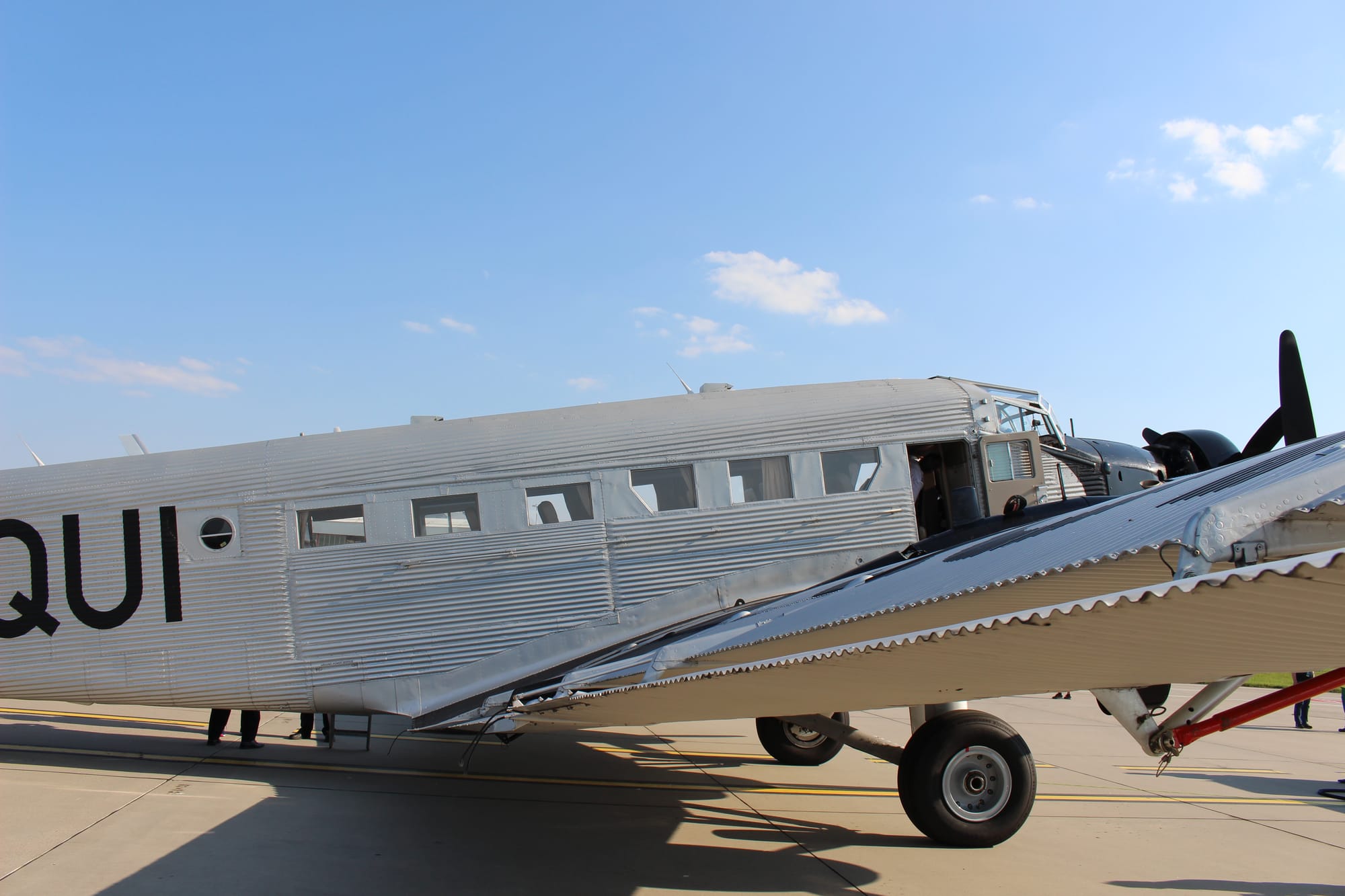 Slightly closer in, showing the six passenger windows, front escape door and main landing gear.