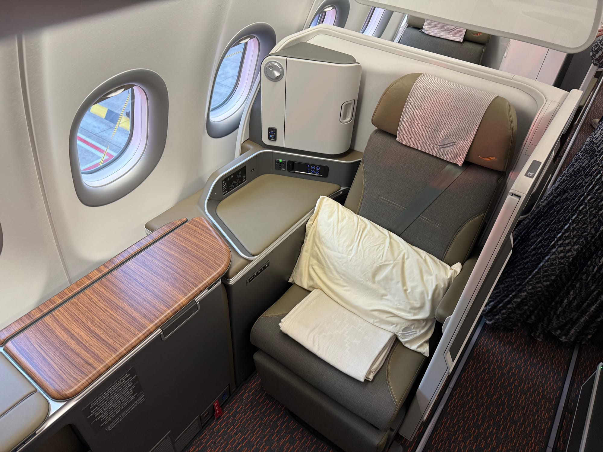Interior, studio class cabin, window seat. The side table console is extended with a large wooden surface.