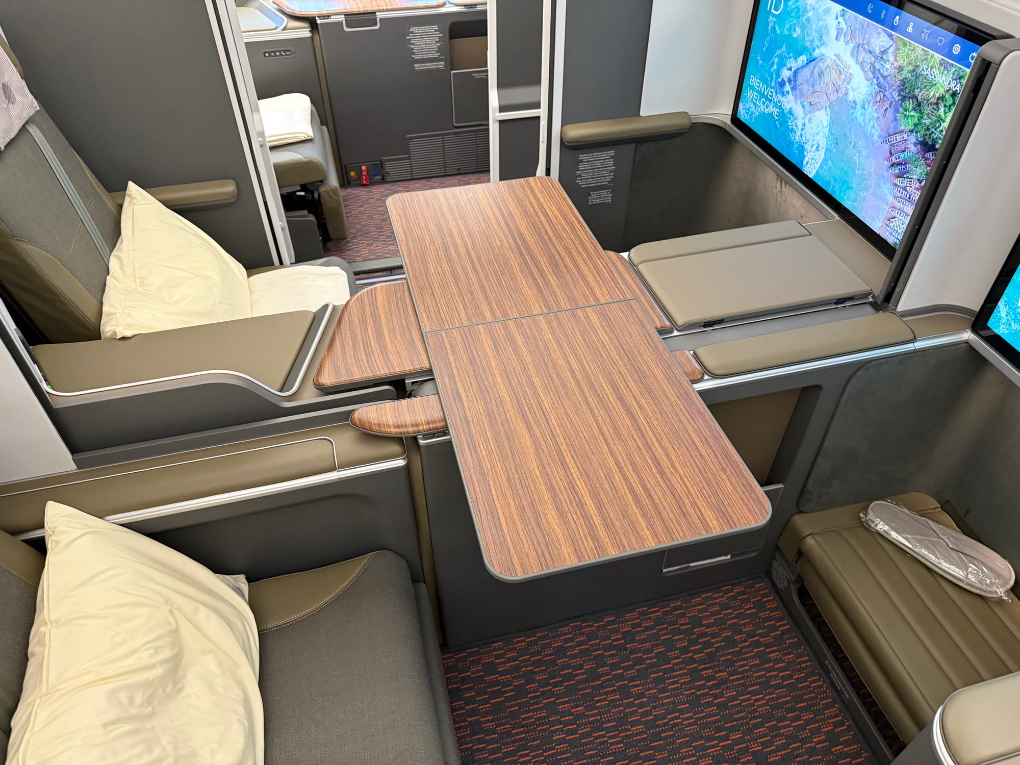 Interior, studio class cabin, same product, looking forwards to the large IFE screen that stretches the width of the suite.