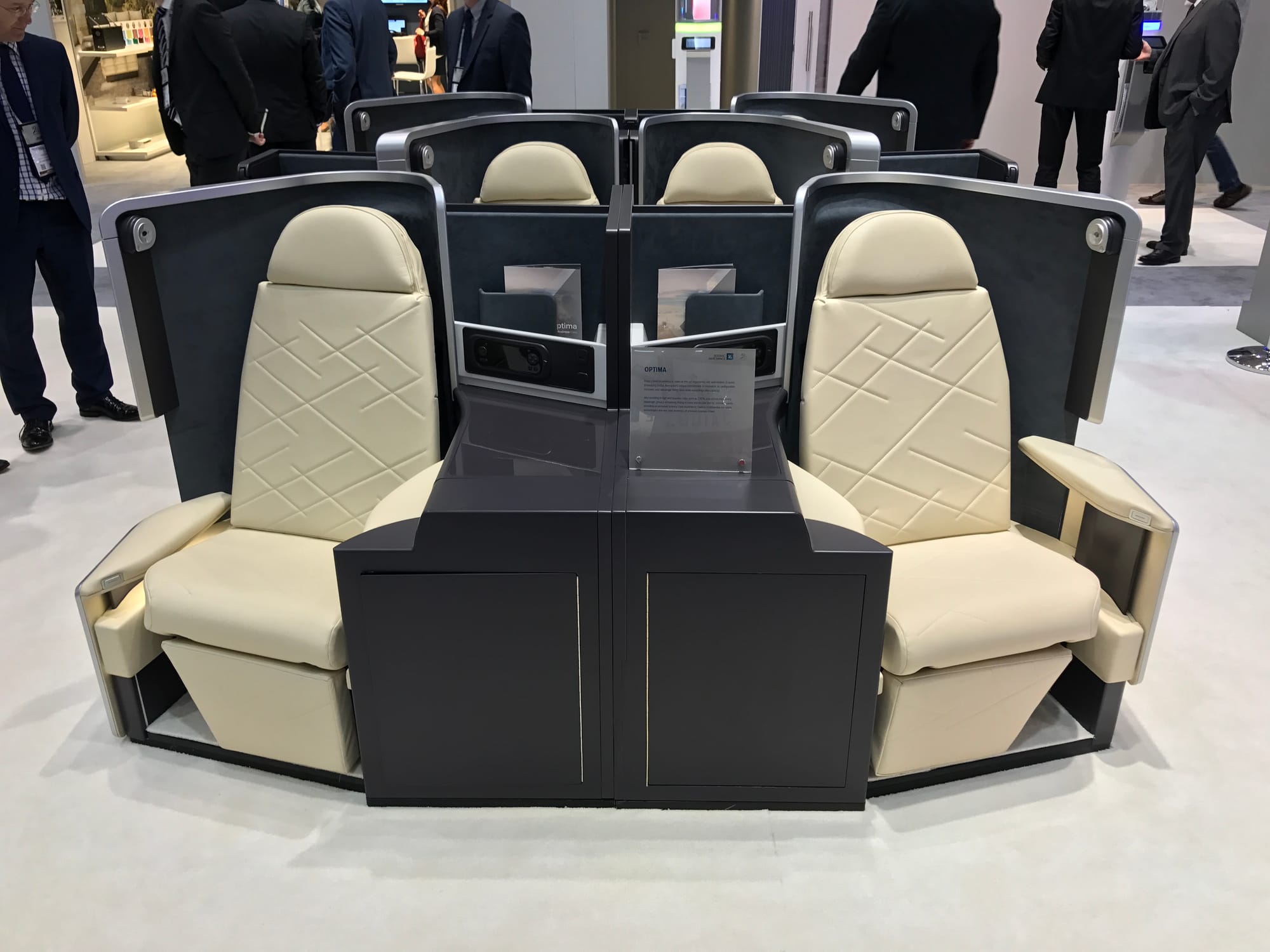 Tradeshow stand with Optima compact staggered business class seat, cream leather, black/grey surrounds.
