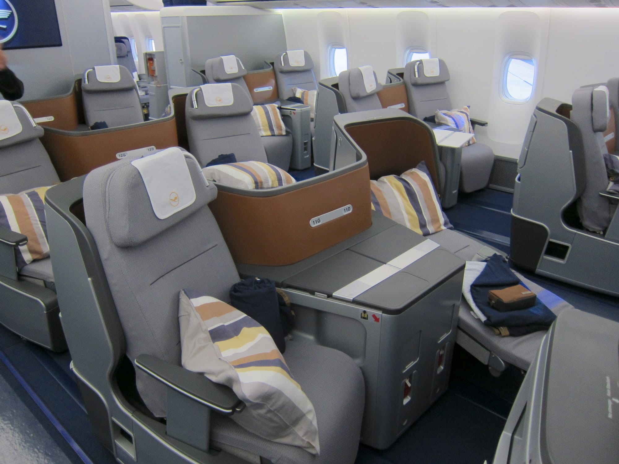 Interior, business class cabin, Boeing 747, 2012 Collins Diamond seats in V-V-V, 2-2-2 layout. CMF is grey with grey and grey and a little brown and blue.