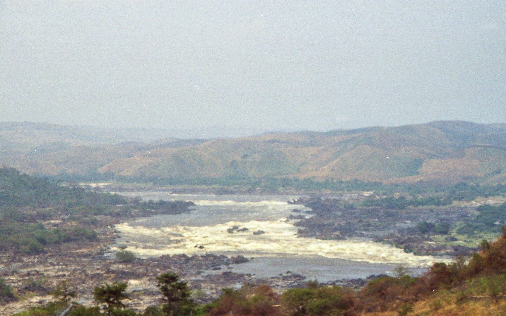 churning, rocky water surrounded by hills.