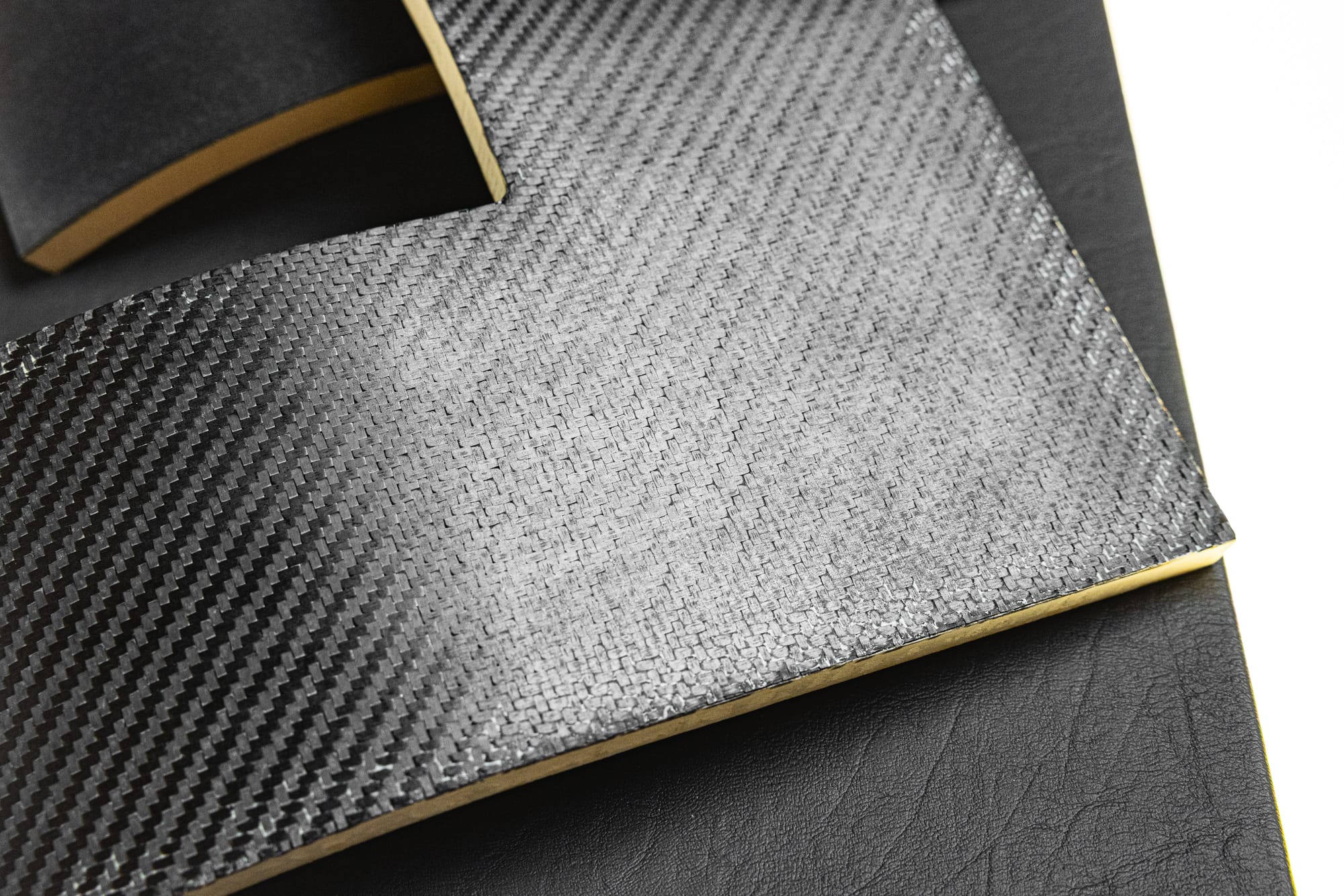 Closeup on a few composite structural elements, one of which has that signature carbon-fibre look to it.