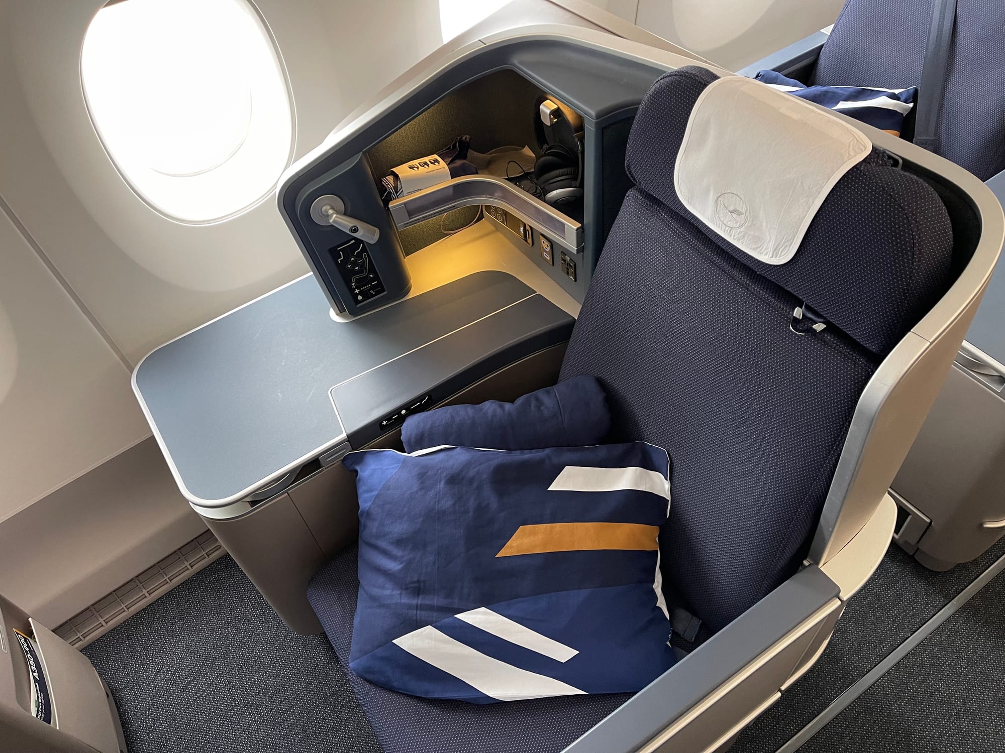 Seat shot, Thompson Vantage XL on an A350. The seat cover and cushions are Lufthansa blue, but the rest of the seat is PAL slate grey with a similar teal carpet to the PAL A350.