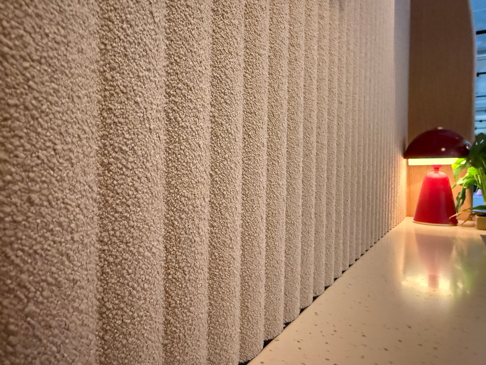 Closeup on a beige vertically ribbed acoustic panel, slightly fluffy fabric.
