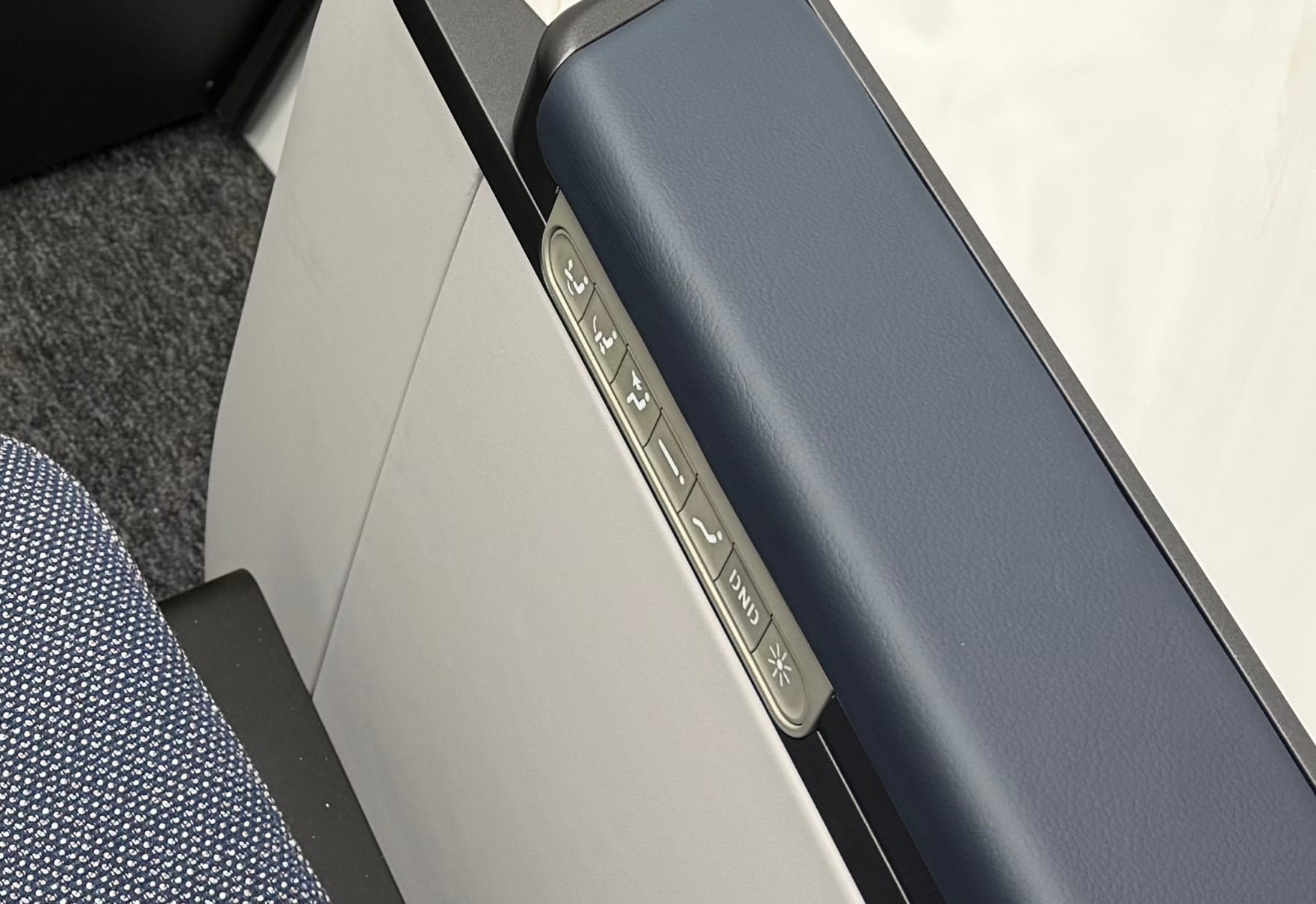 An armrest with seven physical buttons to control the seat and environs, including a do not disturb and light button.