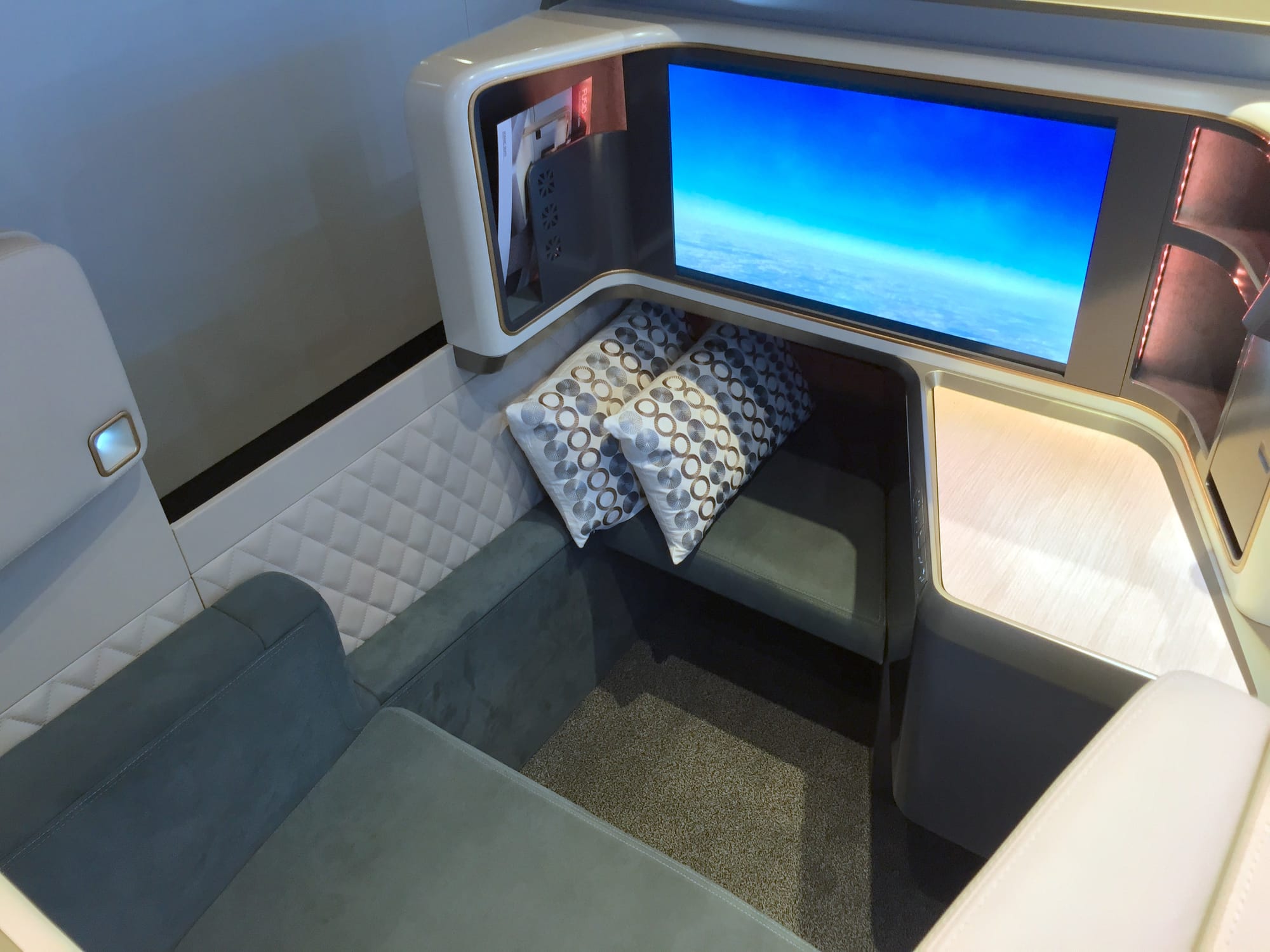 Zodiac Fusio mockup, in calm greens and neutrals, looking forward at the footwell and big screen.