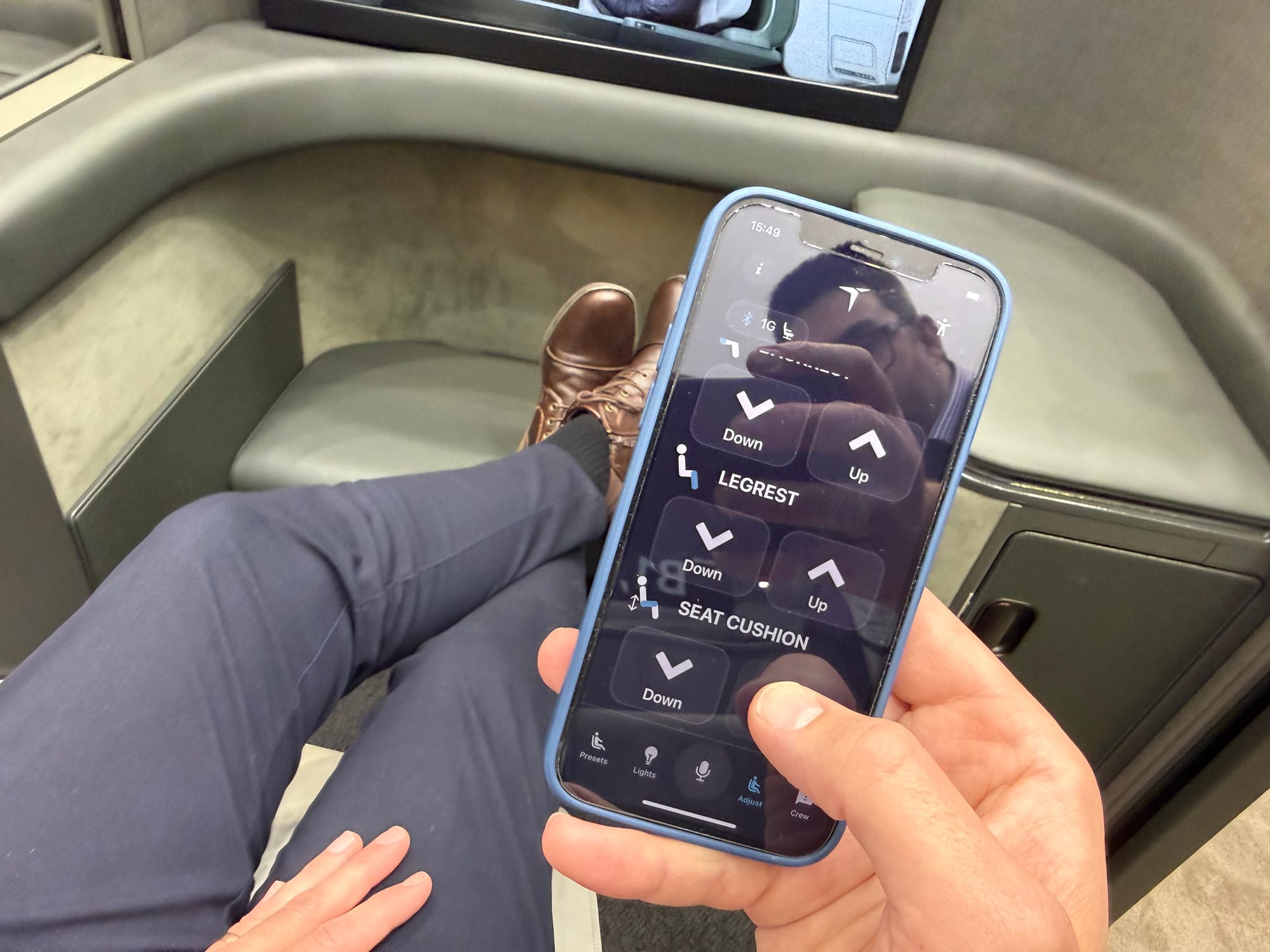 An iPhone in front of a seat. Controls for legrest and seat cushion going down and up are clear and large.