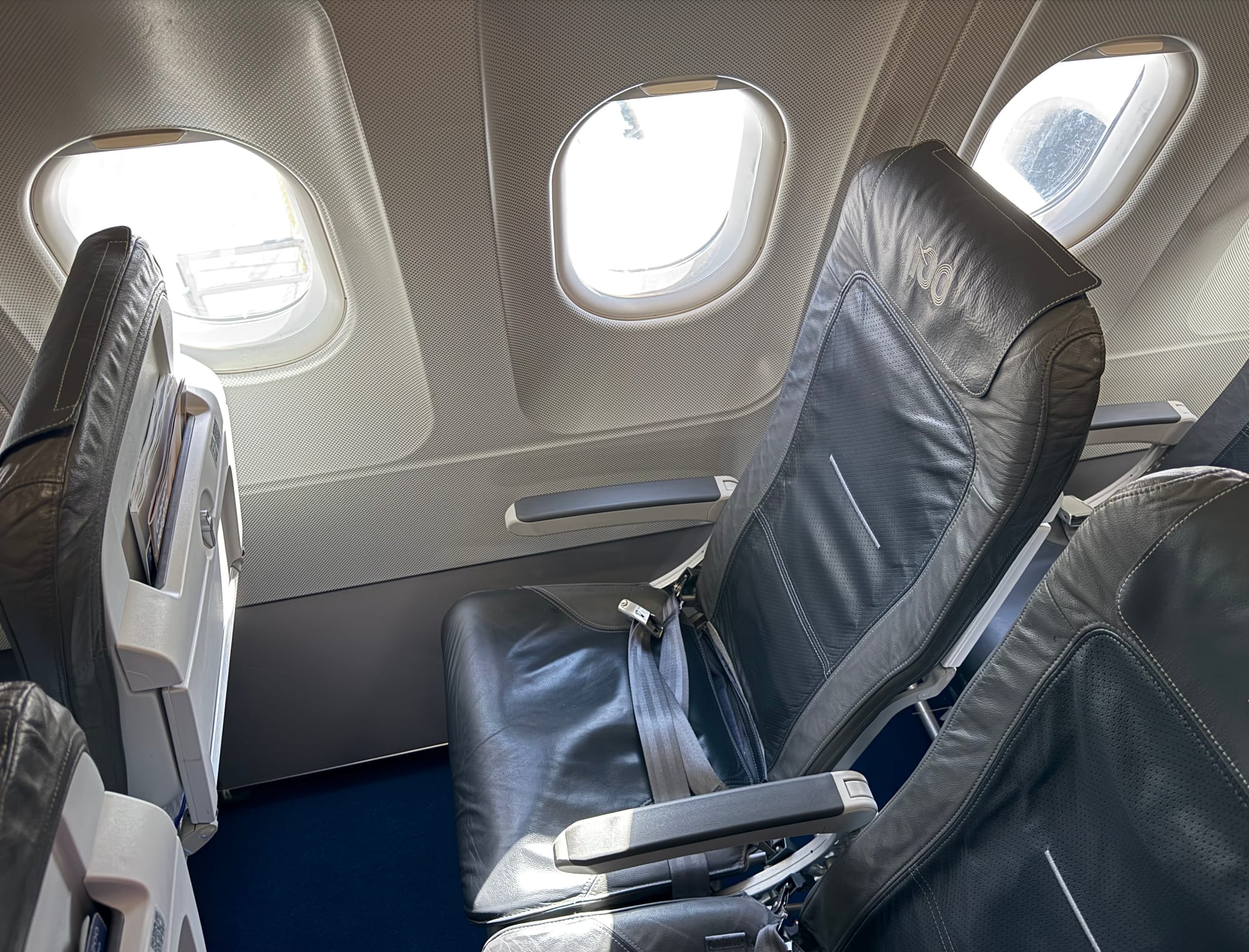 A grey slimline seat with grey seatbelts and trim.