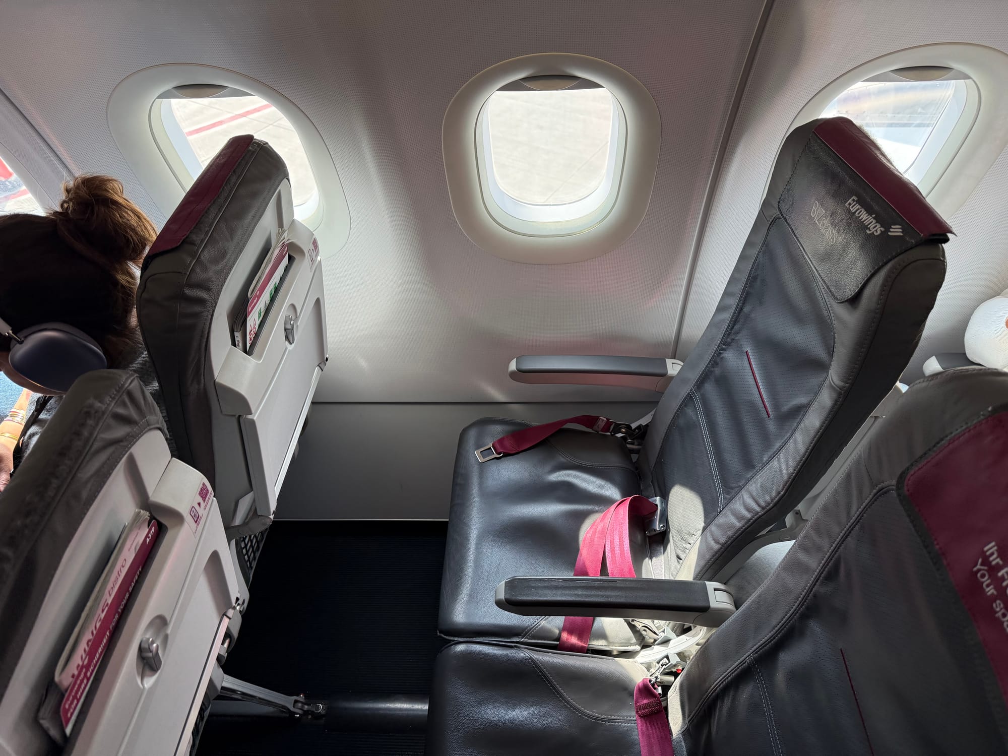 A Eurowings BIZclass-branded slimline seat with magenta-burgundy accents