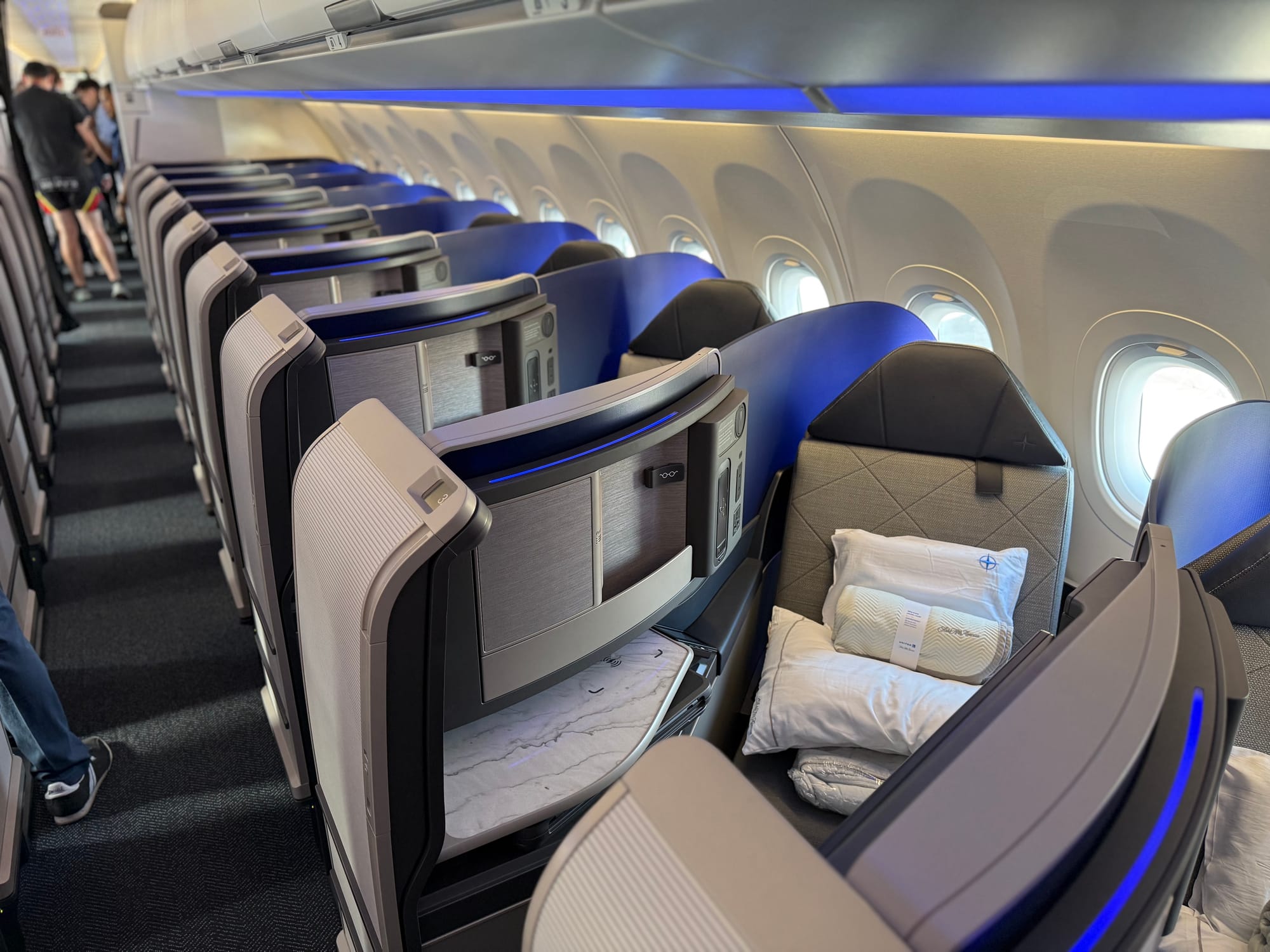 View of the right aisle, same seats. There is a sweeping blue translucent divider between each seat.