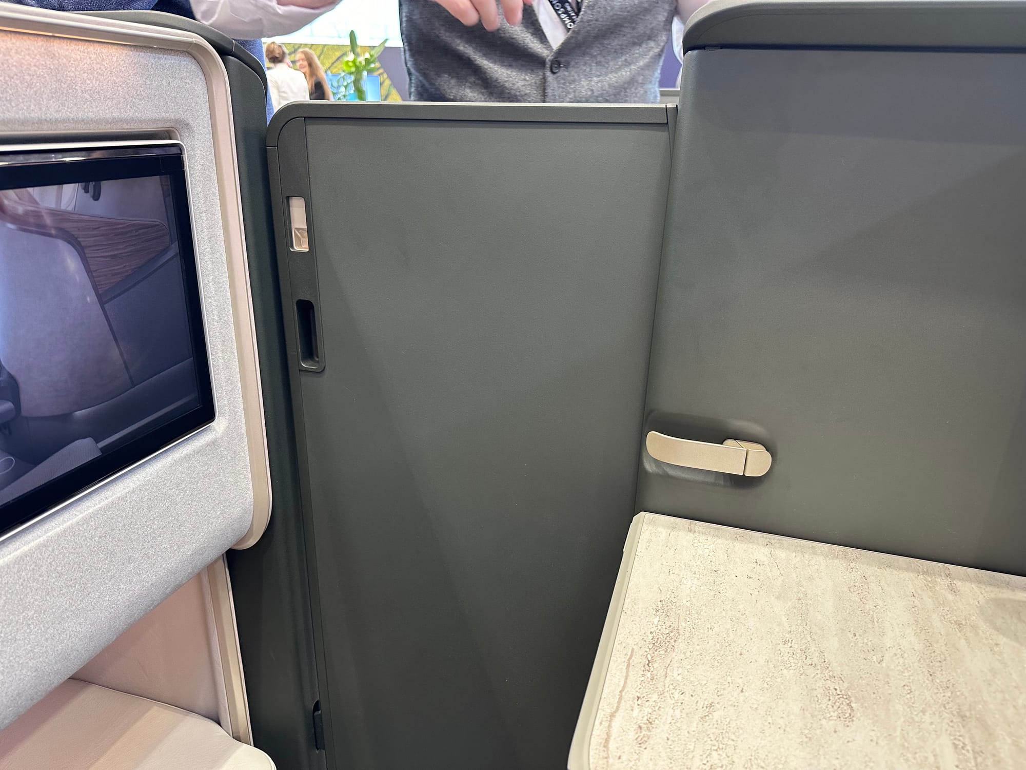 Trade show floor, staggered Thompson Vantage XL suite, looking at the closed door and a person beyond from a seated position.