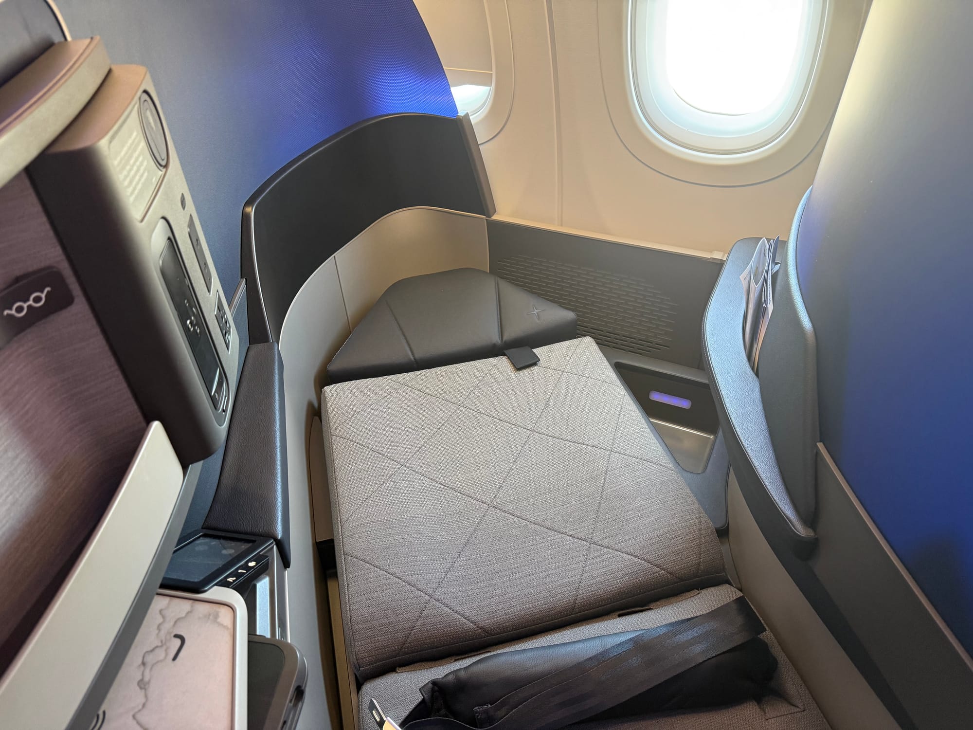 The seat reclined flat but with no bedding. It looks quite tight around the shoulders.
