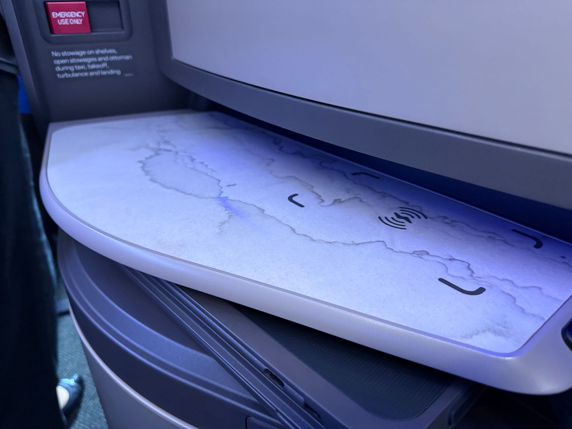 A stonetopped side table with a wireless charging zone outlined, with a lightning bolt and wireless symbol lines.