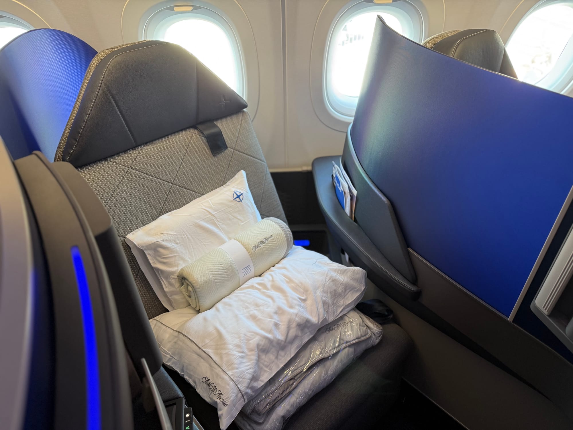The seat in seated mode, with five white/offwhite soft product items as per the previous paragraph on top.