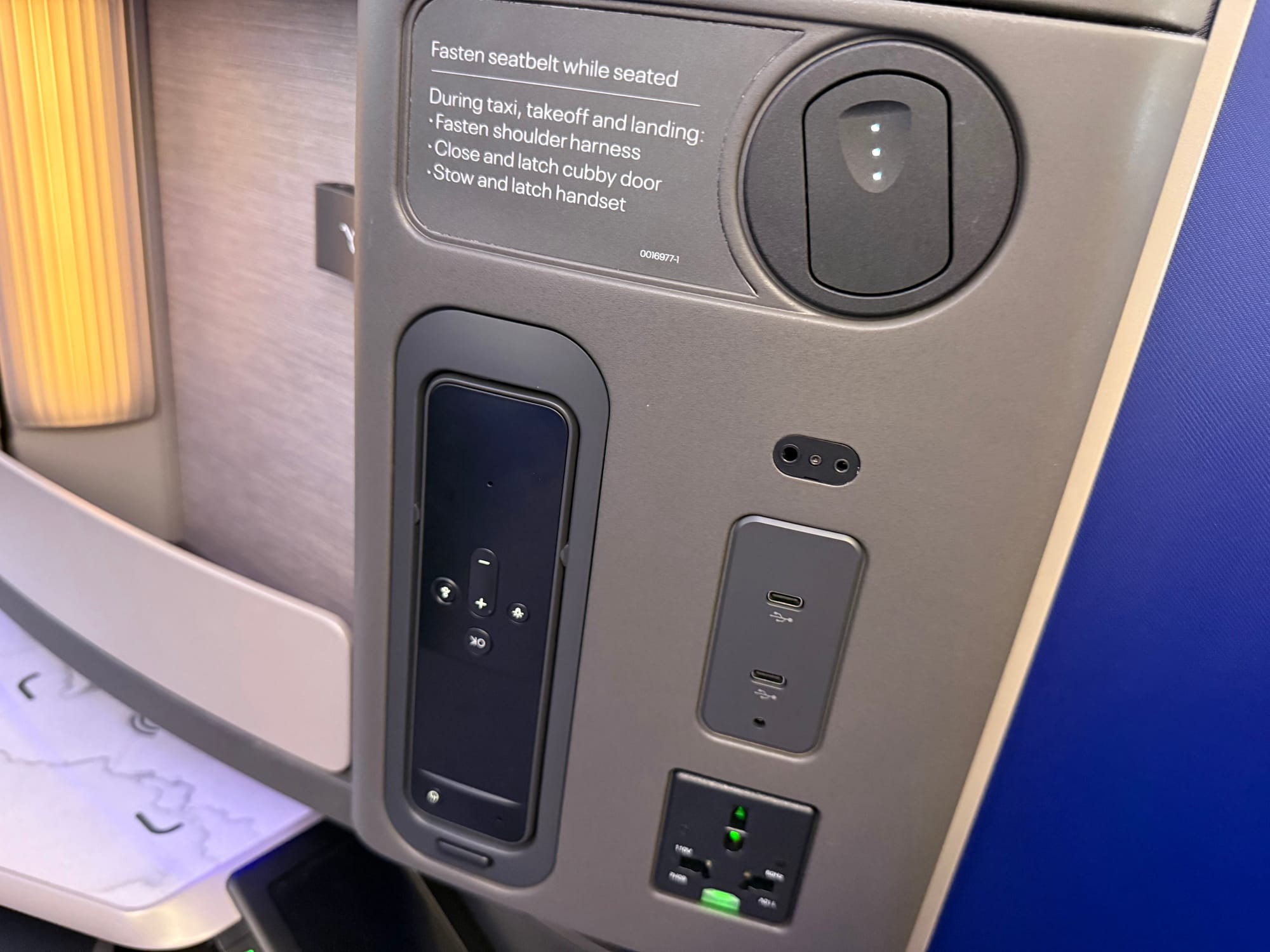 The side assembly, with the IFE remote visibly upside down: the label “OK” is inverted.