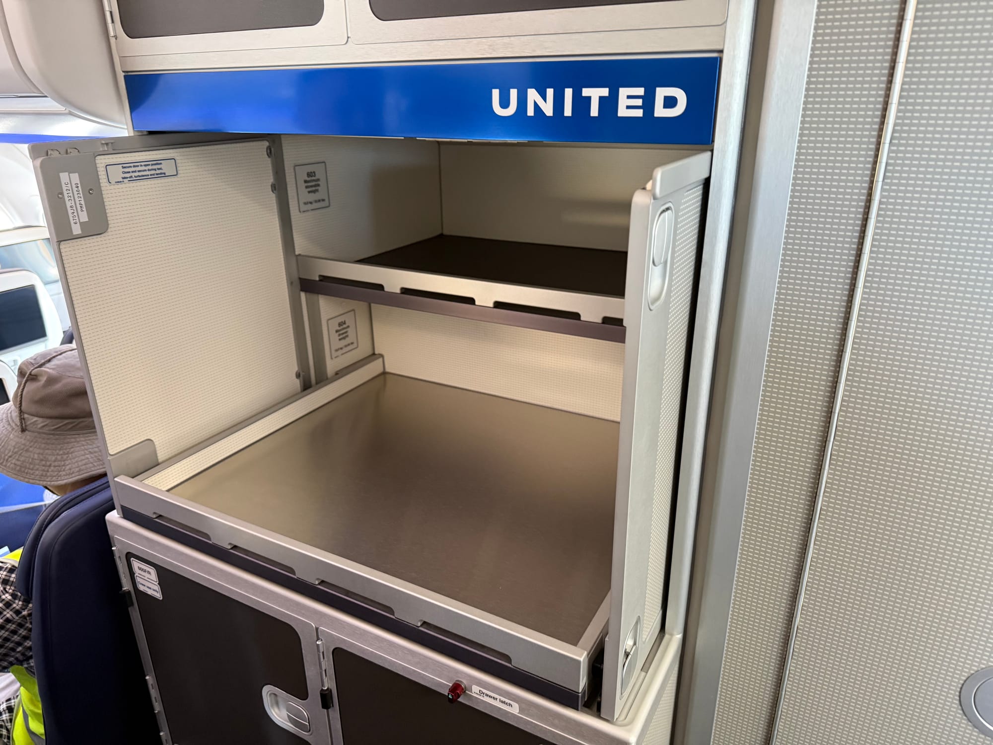 A latch-and-lock self-service area with two shelves, with United branding, mostly greige industrial thermoplastics.