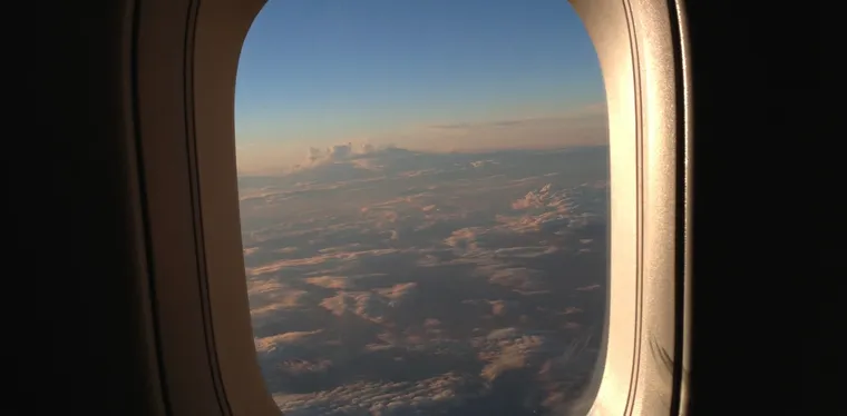 A sunset over clouds, viewed from an airplane window