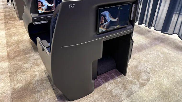 Closeup on a seatback with a curved side at a trade show.