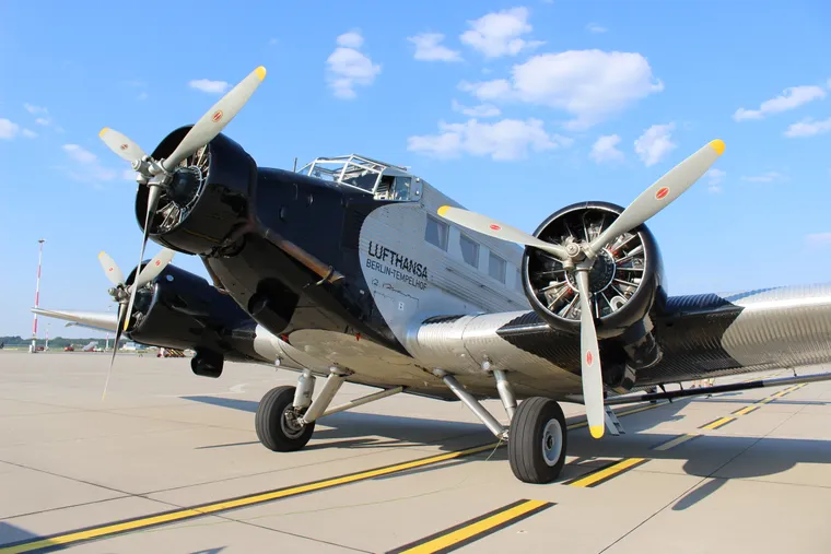 A Ju 52 trimotor sits on the airport tarmac.