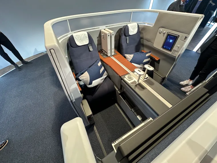 Lufthansa business suite seats in grey and blue with hint of brown on display on a stand
