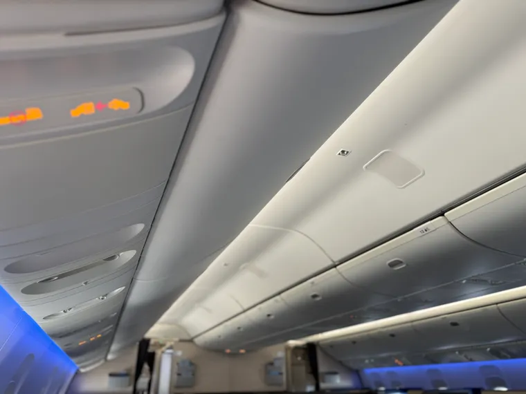 A Boeing 777 interior’s ceiling and sidewalls, with some blue mood lighting