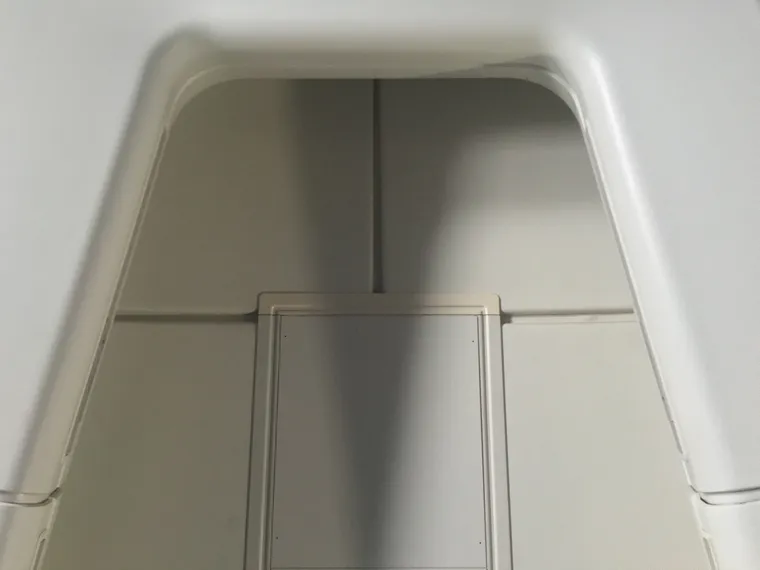 Interior airline cabin, looking up at the ceiling with the front overhead bins of a Boeing 747 nose cabin