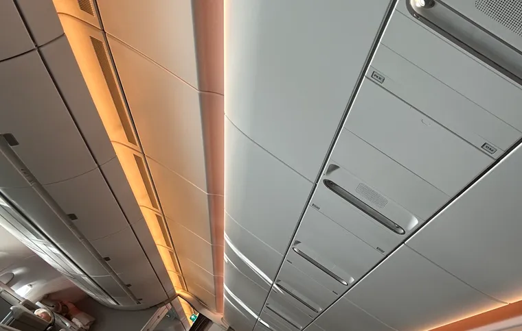 A tilted photo of a widebody cabin, with orange mood-lighting