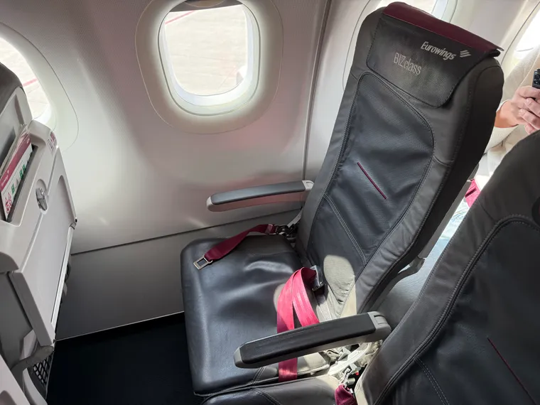 A Eurowings BIZclass-branded slimline seat with magenta-burgundy accents