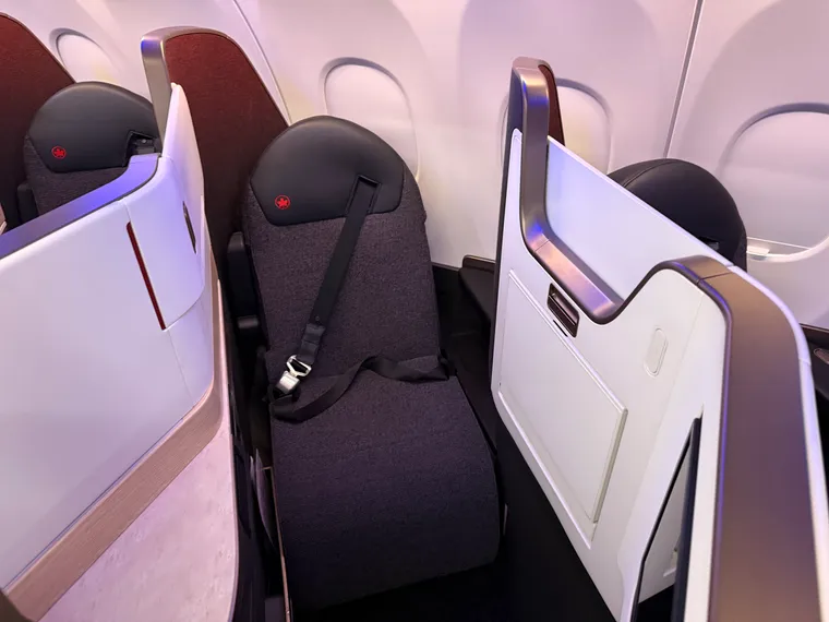 A wide shot of the AC A321XLR seat, an inward-facing herringbone in warm neutrals and reds.