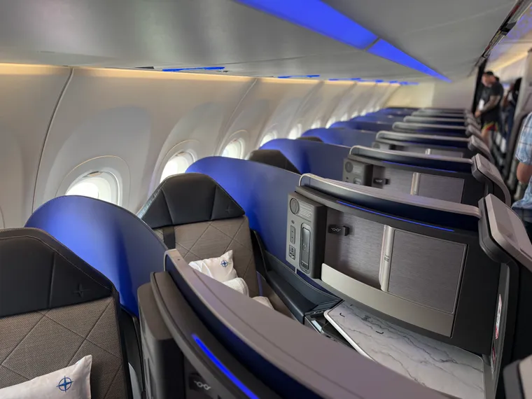 One side of the A321XLR business class, blue and grey inward-facing herringbone business class seats.