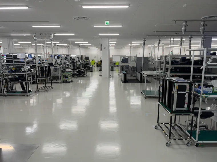 Interior, IFE manufacturing facility, a bright white factory floor with workstations